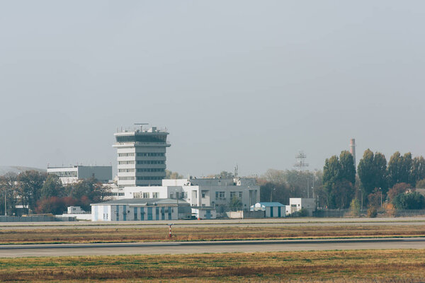ВПП на аэродроме со зданиями аэропорта на заднем плане
