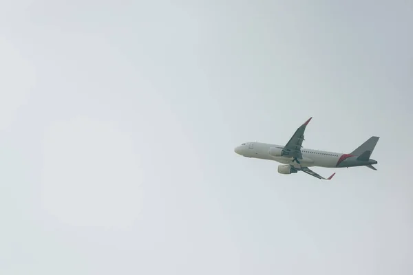 Χαμηλή Γωνία Προβολής Του Εμπορικού Αεροπλάνου Στον Συννεφιασμένο Ουρανό — Φωτογραφία Αρχείου