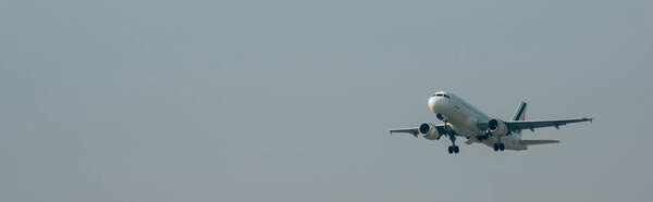 Departure of jet plane in cloudy sky, panoramic shot with copy space