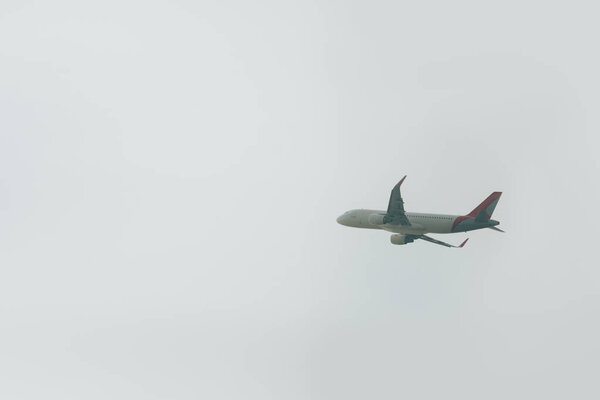 Low angle view of flight departure of plane in cloudy sky 
