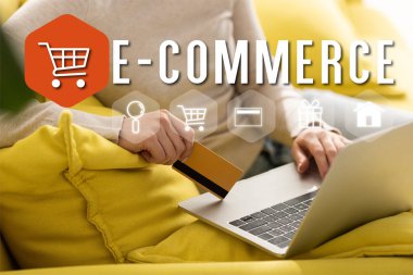 Kredi kartı tutan ve resimleme, e-ticaret konsepti yakınında dizüstü bilgisayar kullanan bir kadın görüntüsü.
