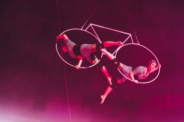 Kyiv, Ukrayna - 1 Kasım 2019: Sirkte metal halkalı esnek hava jimnastikçileri