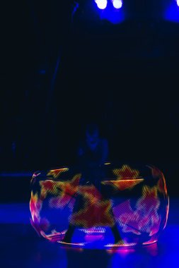 Sanatçı sirkte neon dairesiyle ışık gösterisi yapıyor. 