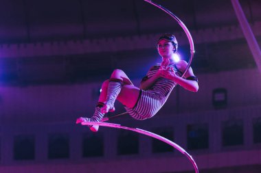 KYIV, UKRAINE - NOVEMBER 1, 2019: Air gymnast applauding while performing with equipment in circus clipart