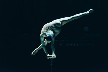 Kyiv, Ukrayna - 1 Kasım 2019: Esnek jimnastikçi amuda kalkarken ve sirkte tek başına sirkte ayrılırken