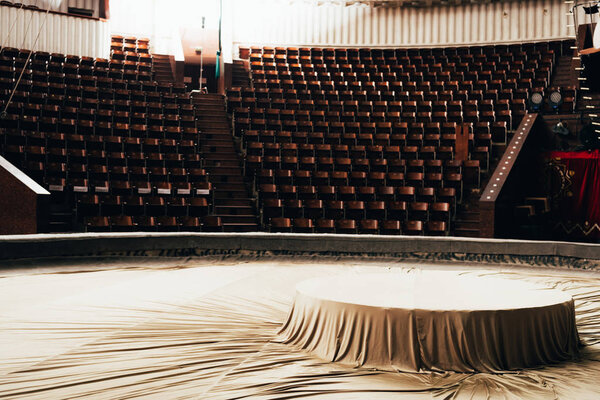 Выборочный фокус покрытия на цирковой арене с сиденьями на заднем плане
