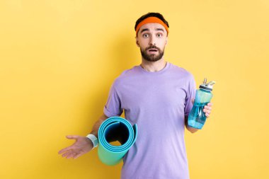 Şaşırtıcı sporcunun elinde spor şişesi ve spor paspası vardı.
