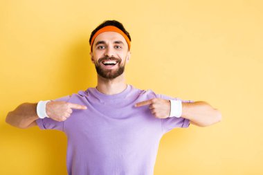 Saç bantlı mutlu sporcu sarıyı işaret ediyor.