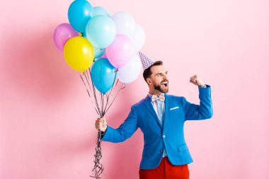 excited businessman holding balloons on pink  clipart