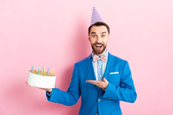 Excited Businessman Party Cap Pointing Hand Birthday Cake Pink — 스톡 사진