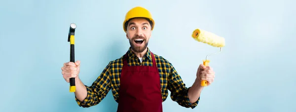 Panoramic Shot Excited Workman Holding Hammer Paint Roller Blue — Stock Photo, Image