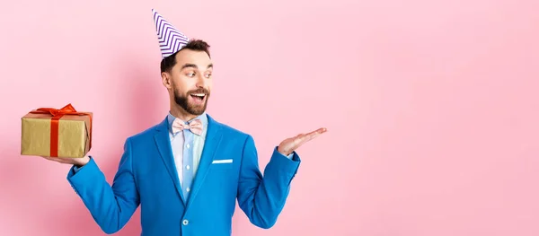 Panoramic Shot Happy Businessman Holding Present Pointing Hand Pink — Stock Photo, Image