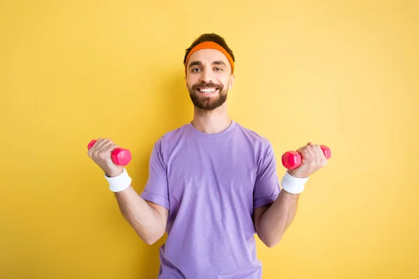 Deportista Positivo Haciendo Ejercicio Con Pesas Rosadas Sobre Amarillo — Foto de Stock