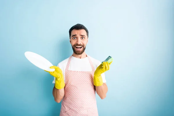 Surprised Man Dotted Apron Holding Plate Sponge Blue — Stock Photo, Image