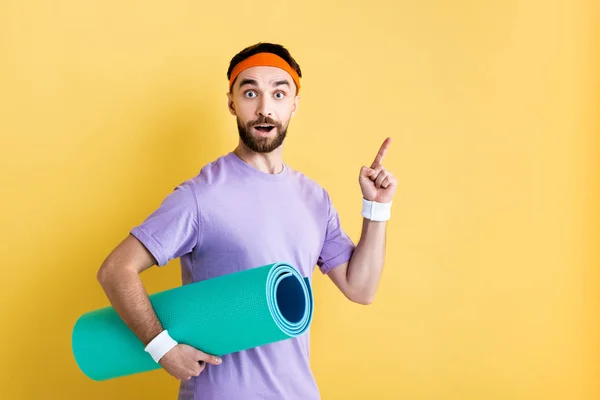 Surprised Sportsman Holding Fitness Mat Pointing Finger Yellow — Stock Photo, Image