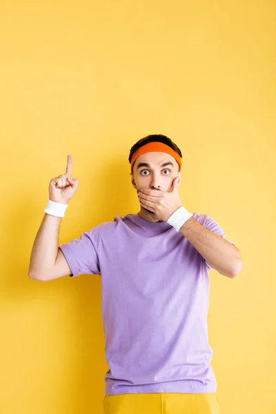 Shocked Sportsman Covering Mouth Pointing Finger Yellow — 스톡 사진