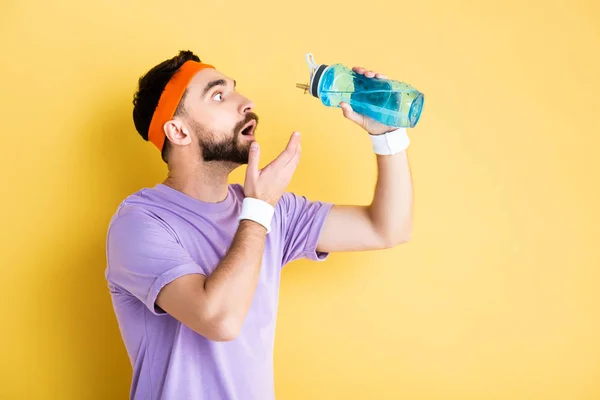 Συναισθηματική Άνθρωπος Ανοιχτό Στόμα Κρατώντας Αθλητικό Μπουκάλι Στο Κίτρινο — Φωτογραφία Αρχείου