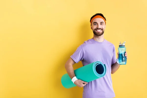 Pozitivní Vousatý Muž Drží Sportovní Láhev Fitness Podložku Žluté — Stock fotografie
