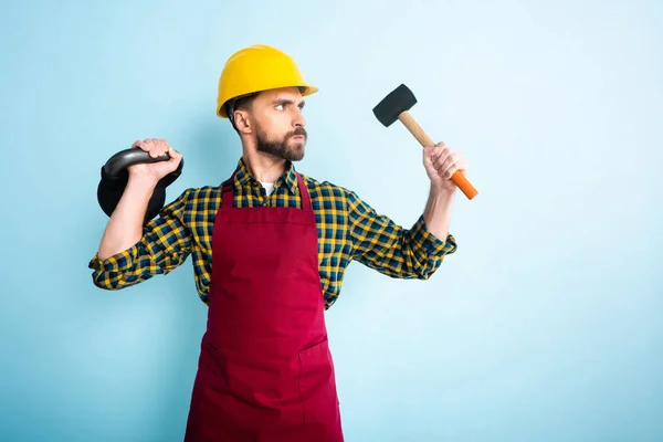 Angry Bearded Workman Safety Helmet Holding Hammer Dumbbell Blue — Stock Photo, Image