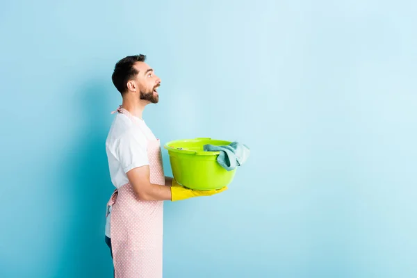 Vista Lateral Del Hombre Barbudo Feliz Sosteniendo Ropa Sucia Azul — Foto de Stock