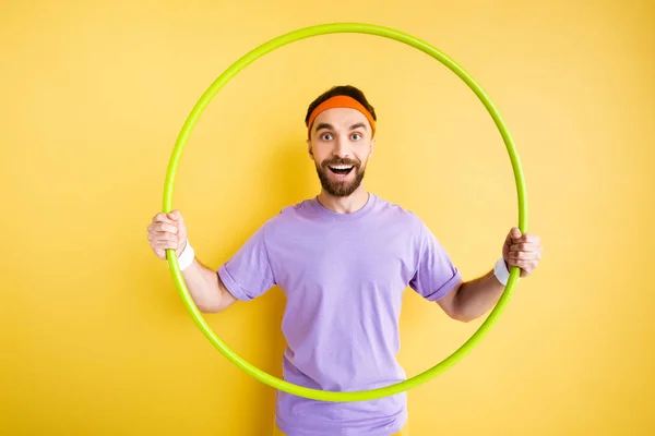 快乐的胡子运动员拿着呼啦圈挂在黄色的上面 — 图库照片