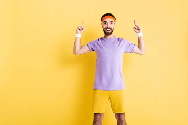 Glücklicher Mann Mit Stirnband Zeigt Mit Den Fingern Auf Gelb — Stockfoto