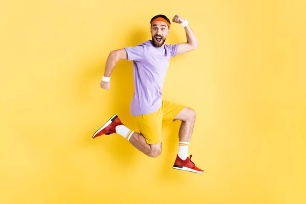 穿着运动服快乐的人跳上黄色的衣服 — 图库照片