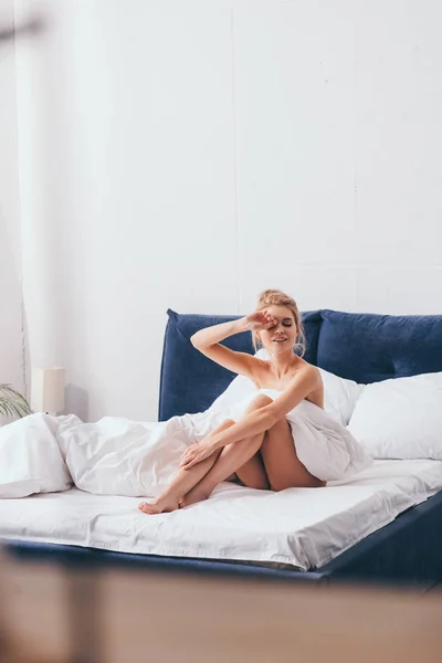 Sabahları Çarşaflı Neşeli Kadın Yatakta Oturuyor — Stok fotoğraf