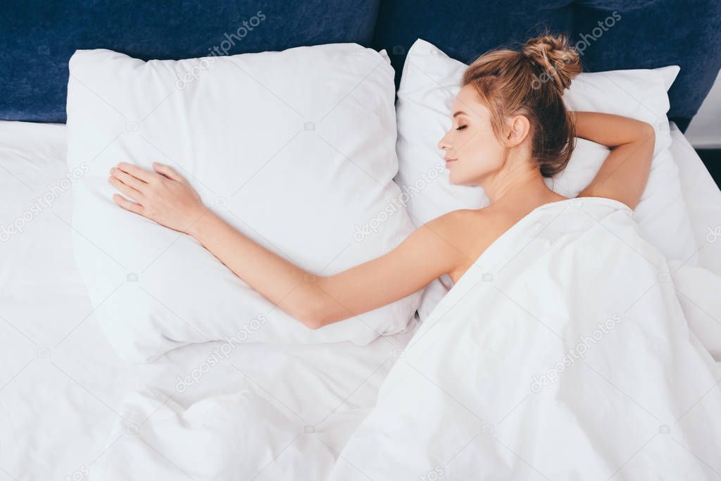beautiful nude woman sleeping in bed in morning
