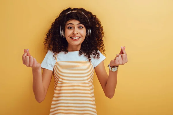 Excited Mixed Race Girl Wireless Headphones Showing Winner Gesture Yellow — Stock Photo, Image