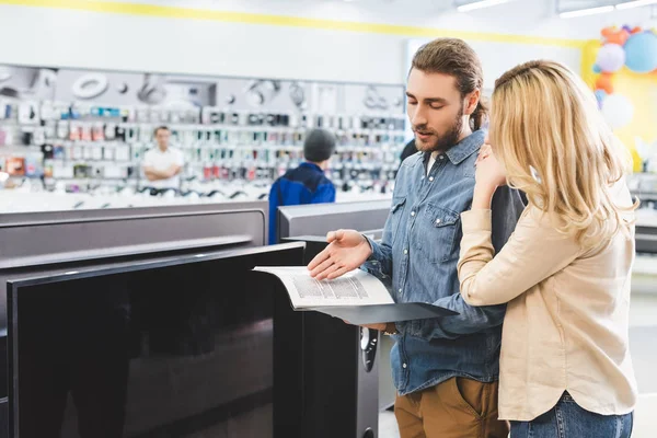 Boyfriend Pointing Hand Folder Talking Girlfriend New Home Appliance Store — Stock Photo, Image