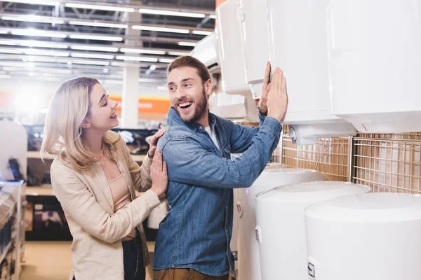 Sorrindo Namorado Tocando Caldeira Olhando Para Namorada Loja Eletrodomésticos — Fotografia de Stock