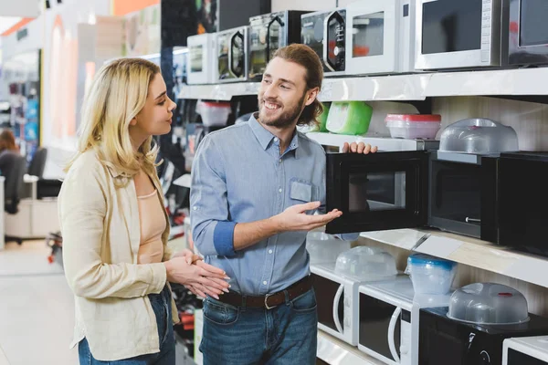 Consultor Sorridente Apontando Com Mão Para Microondas Conversando Com Mulher — Fotografia de Stock