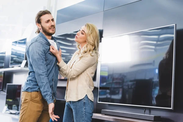 Freundin Fragt Traurigen Freund Vor Fernseher Haushaltsgerätegeschäft — Stockfoto