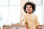 Nízký úhel pohledu na africké americké dítě s úsměvem při pohledu pryč