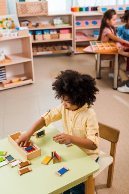 Montessori okulunda çocuklarla oyun oynayan çocukların seçici odak noktası