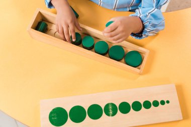 Montessori okulundaki masada tahta masa oyunu oynayan çocuk manzarası. 