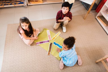 Montessori okulunda çocukların oyunu yerde katlamasının yüksek açılı görüntüsü