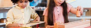 Montessori okulundaki çocukların ahşap oyunlar oynadığı panoramik bir çekim. 