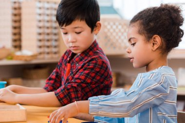 Montessori okulunda eğitim oyunu oynayan çocukların yan görünüşü