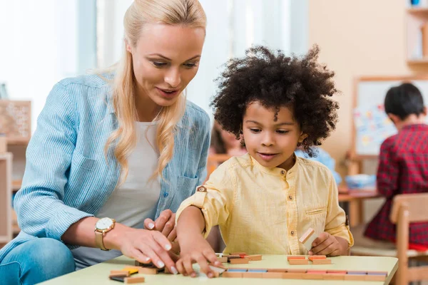 Selective Focus Teacher Helping African American Kid Wooden Game Montessori — 스톡 사진