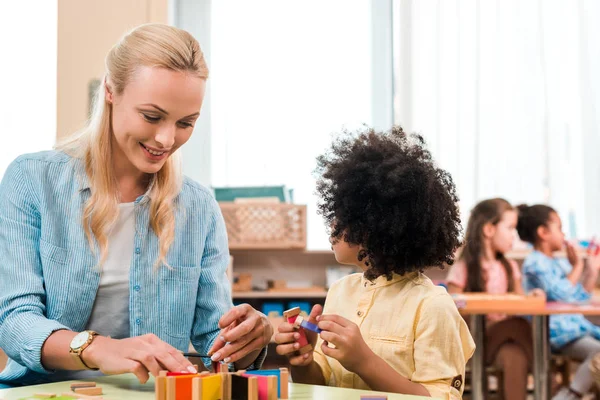 Selective Focus Smiling Teacher Kid Playing Educational Game Children Background — 스톡 사진