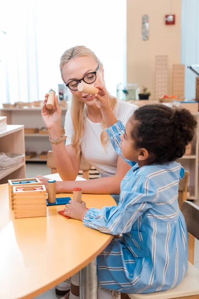 Gülümseyen Öğretmen Montessori Okulunda Tahta Oyunla Oynayan Çocuğa Bakıyor — Stok fotoğraf