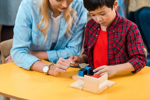 Montessori Sınıfında Asyalı Bir Çocuk Öğretmeninden Yapı Taşı Oyunu Oynuyor — Stok fotoğraf