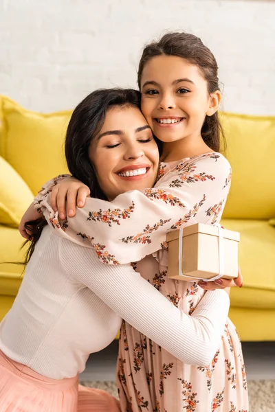 Happy Woman Holding Mothers Day Present While Hugging Adorable Daughter — 스톡 사진