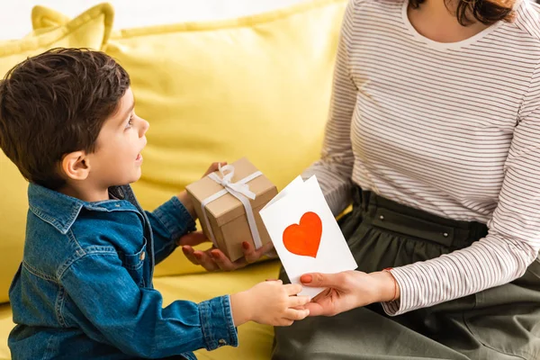 Adorable Boy Presenting Gift Box Mothers Day Card Heart Symbol — Stock Photo, Image