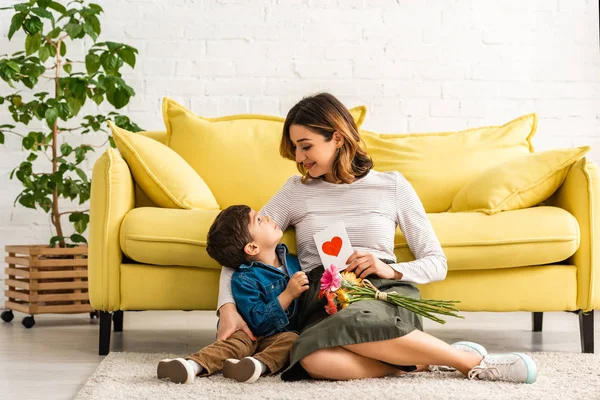 Donna Sorridente Guardando Adorabile Figlio Mentre Seduto Sul Pavimento Con — Foto Stock