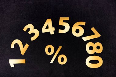 top view of golden numbers and percent sign on black background clipart