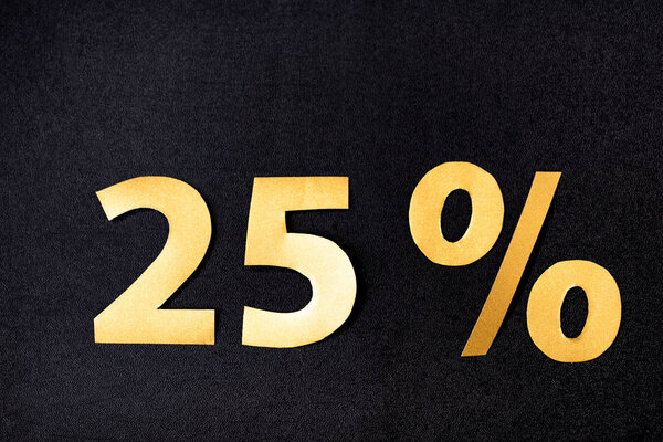 верхний вид золотых 25 процентов знаков на черном фоне

