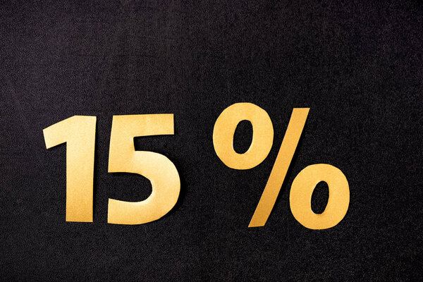 верхний вид золотых 15 процентов знаков на черном фоне
